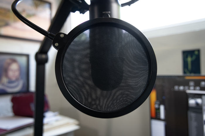 Attaching an inexpensive pop shield will help reduce the plosives - those puffs of air produced by 'P' and 'B' sounds